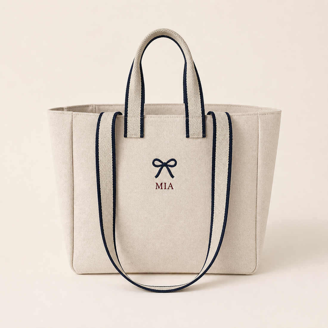 Off White contrast-strap canvas tote with example embroidery of a navy bow and MIA, front view