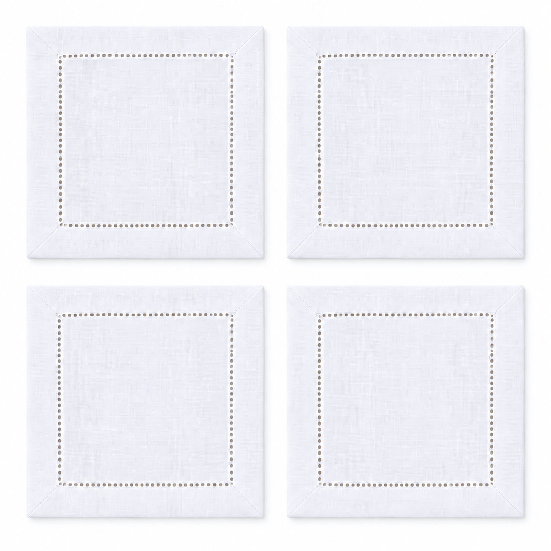 Set of four white hemstitch cocktail napkins laid out in a two-by-two grid